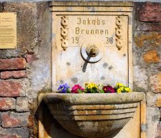 Leimener Jakobsbrunnen mit neuer Informationstafel und Blumenschmuck