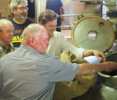 Sandhäuser Delegation gibt bei Welde selbstgeernteten Hopfen in den Sud