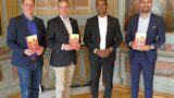 Pfarrer Arul Lourdu stellt den hiesigen Bürgermeistern seine neuen Bücher vor