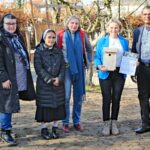 MdL Christiane Staab und Pfarrer Arul Lourdu hängen Nistkasten im KiGa auf