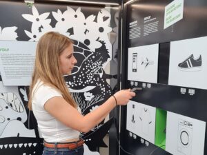 Jugendliche scannt interaktive Darstellung in der Ausstellung „Planet A*“ im Zoo Heidelberg.