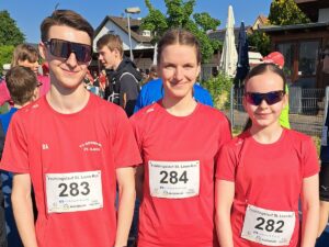 Drei Jugendliche in roten TV Germania Shirts mit Startnummern beim Frühlingslauf St. Leon-Rot 2025