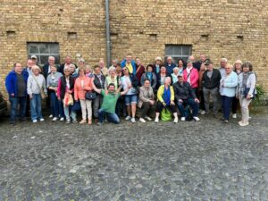 Gruppenfoto des VdK Leimen mit rund 40 Personen vor einer Backsteinfassade in Wiesbaden während eines Tagesausflugs am 17. Mai 2025.