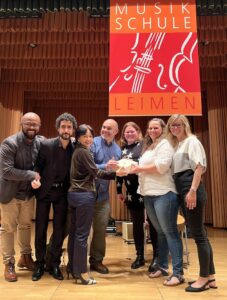 Gruppenfoto mit Musiker:innen und Team der Musikschule Leimen vor einem Banner mit dem Schriftzug „Musikschule Leimen“.