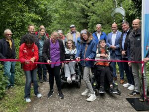 Gruppenfoto bei der Eröffnung des Komfort-Wanderwegs in Dossenheim, mit Schülerinnen, Lehrkräften, Politikerinnen und Projektbeteiligten beim symbolischen Banddurchschnitt.