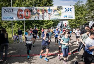 Läuferinnen und Läufer starten beim GO-ZAP-Lauf in Nußloch unter dem Startbanner.