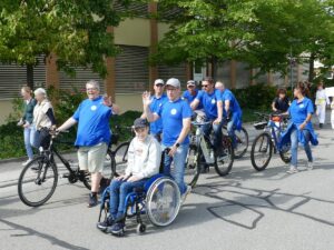 Gruppe mit historischen Fahrrädern und einem Kind im Rollstuhl beim Kerweumzug.