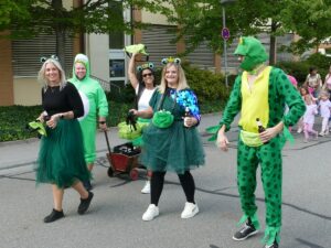 Gruppe in Froschkostümen, grünem Tüll und Partylaune beim Kerweumzug.