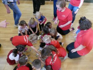 Kinder sammeln gespendete Kerwetaler auf dem Hallenboden des TV Germania St. Ilgen.