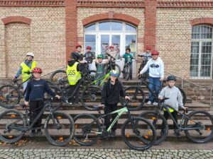 Schülergruppe mit Fahrrädern und Helmen auf den Treppen der Alten Fabrik