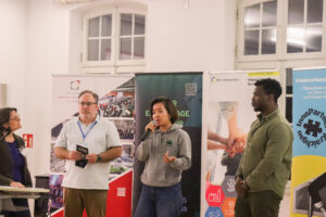 Personen vor Werbematerialien mit dem Thema KI-Lösungen.