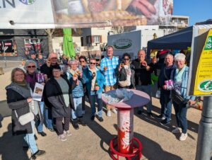 Eine Gruppe von Besucherinnen und Besuchern hält gefärbte Ostereier auf dem Wochenmarkt in St. Ilgen in die Kamera.