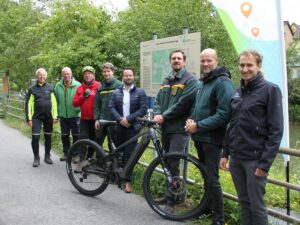 Gruppenfoto der Beteiligten vor der Starttafel der neuen Mountainbike-Strecke Ng2 mit Mountainbike bei der Eröffnung in Neckargemünd.