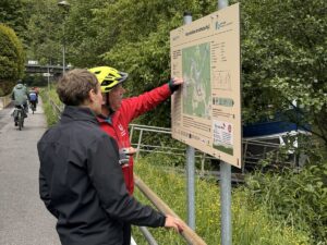 Zwei Personen betrachten die Informationstafel der neuen Mountainbike-Rundstrecke Ng2 in Neckargemünd am Startpunkt im Elsenzweg.