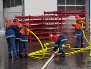Junge Feuerwehrleute halten gemeinsam ein Strahlrohr