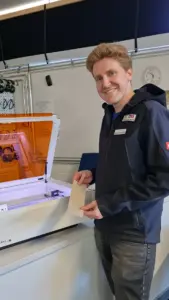Dr. Lukas Frese steht im Techniklabor des Zoo Heidelberg neben einem Laserschneider.